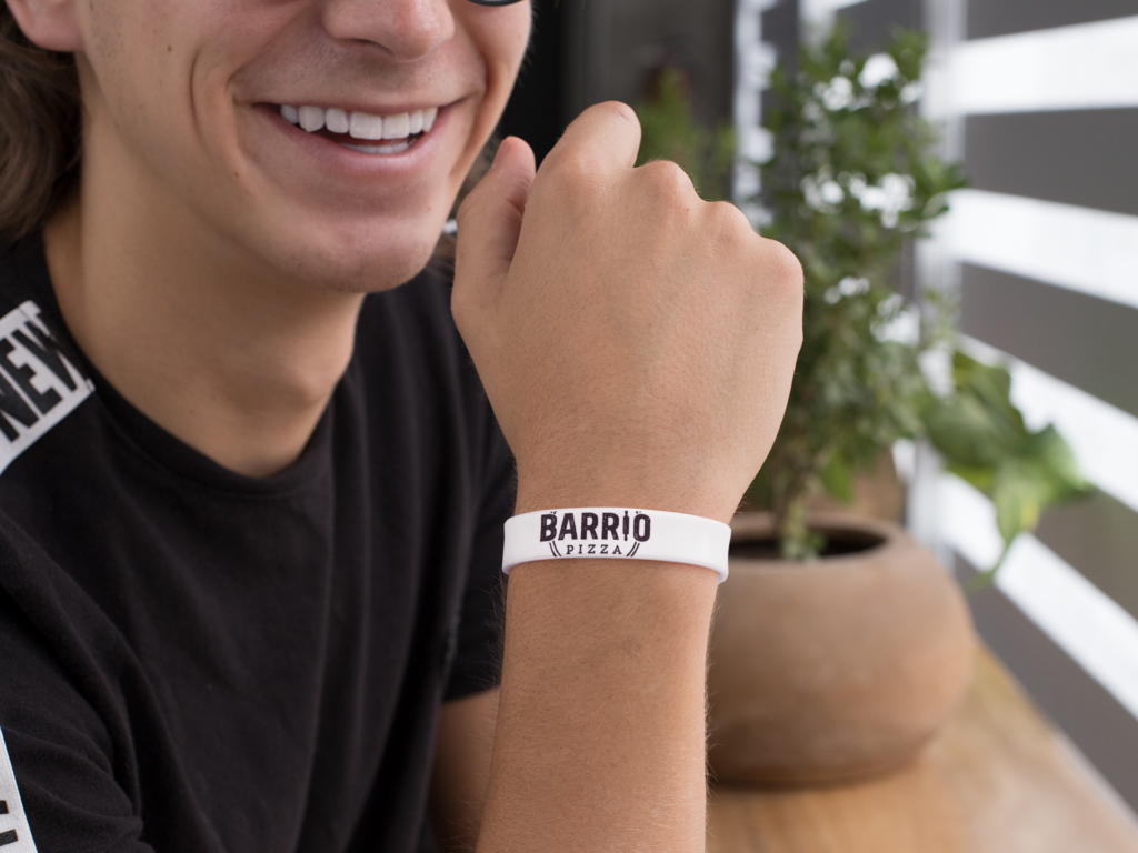 silicone-wristband-mockup-featuring-a-smiling-guy-by-a-plant-pot-28244